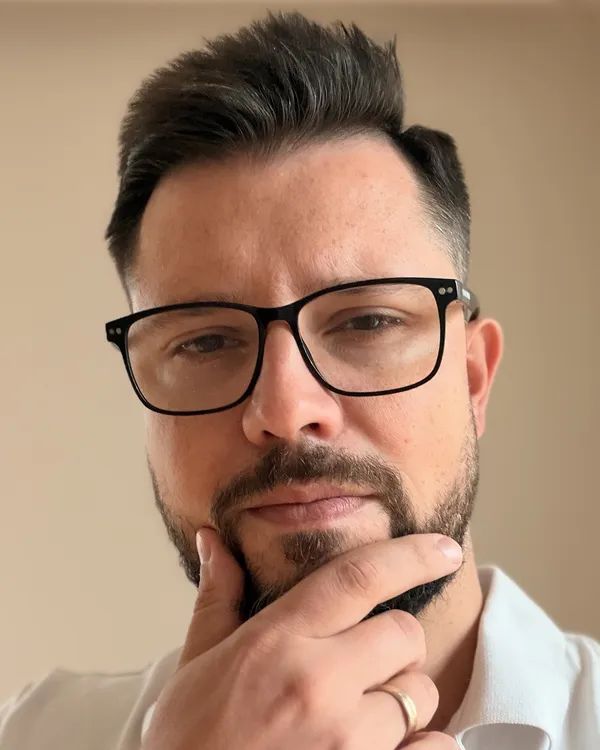 Marcin Kożuchowski w zamyśleniu, z dłonią przy brodzie